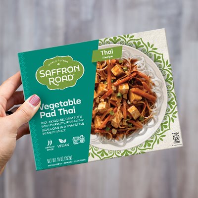 A hand holding the package of Vegetable Pad Thai Frozen Meal Frozen Dinners saffron-road-b2c 