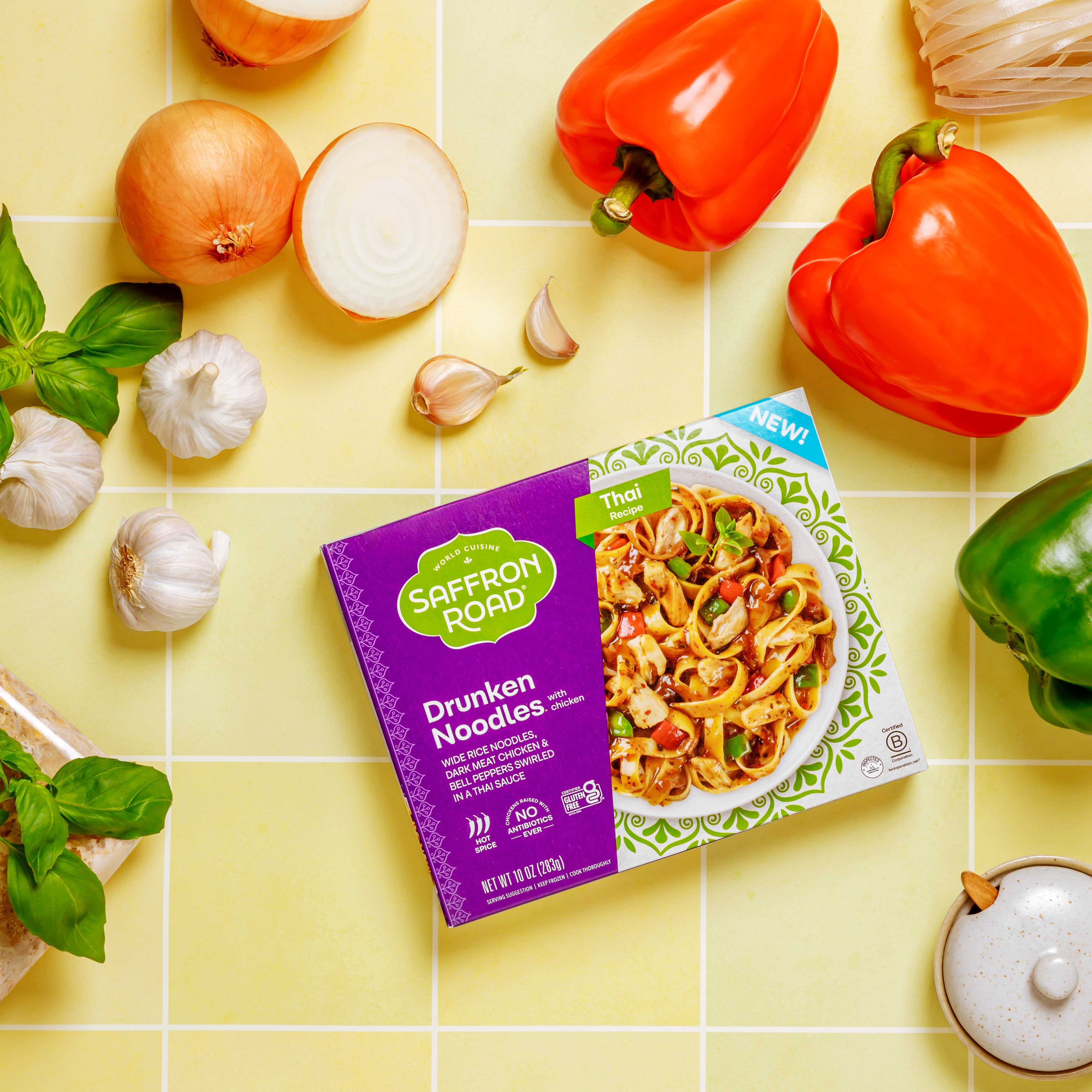 Drunken Noodles with Chicken Frozen Dinner package on yellow background with ingredients